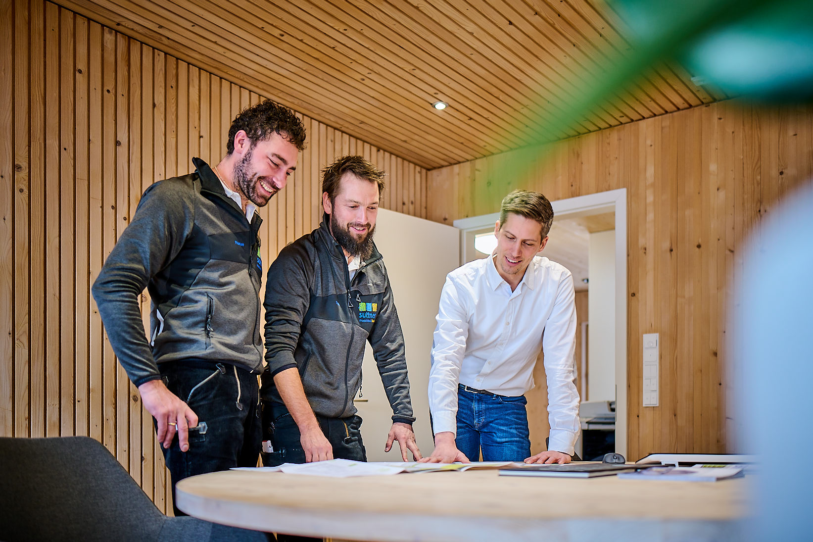 Projektleiter bei Planbesprechung in Besprechungsraum mit Akustikdecke