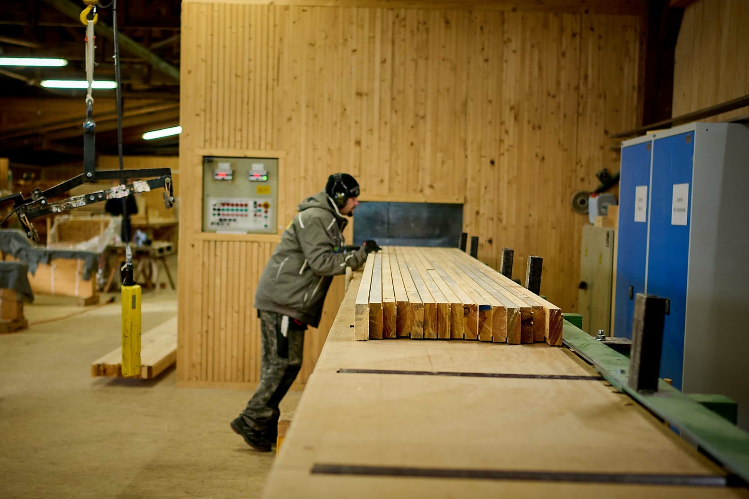 Produktionsmitarbeiter lässt Dübelholzelement durch Hobelmaschine