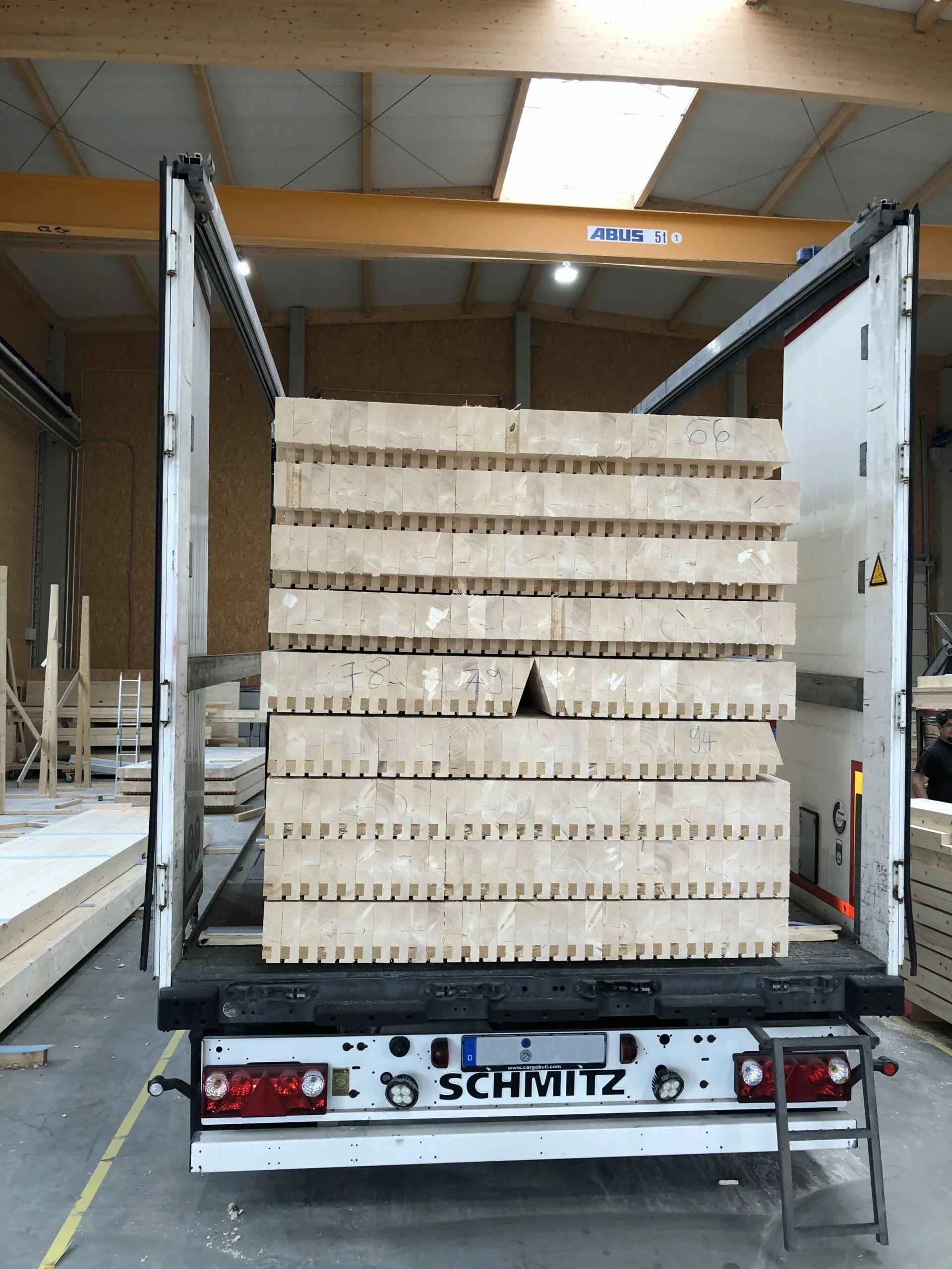 Vorgefertigte Akustikdeckenelemente auf LKW verladen für Transport zur Baustelle