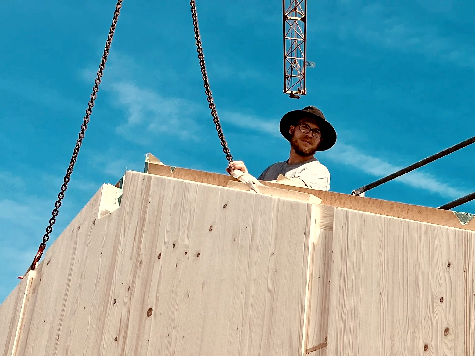 Zimmerer bei Montage von Dübelholzwand auf Baustelle