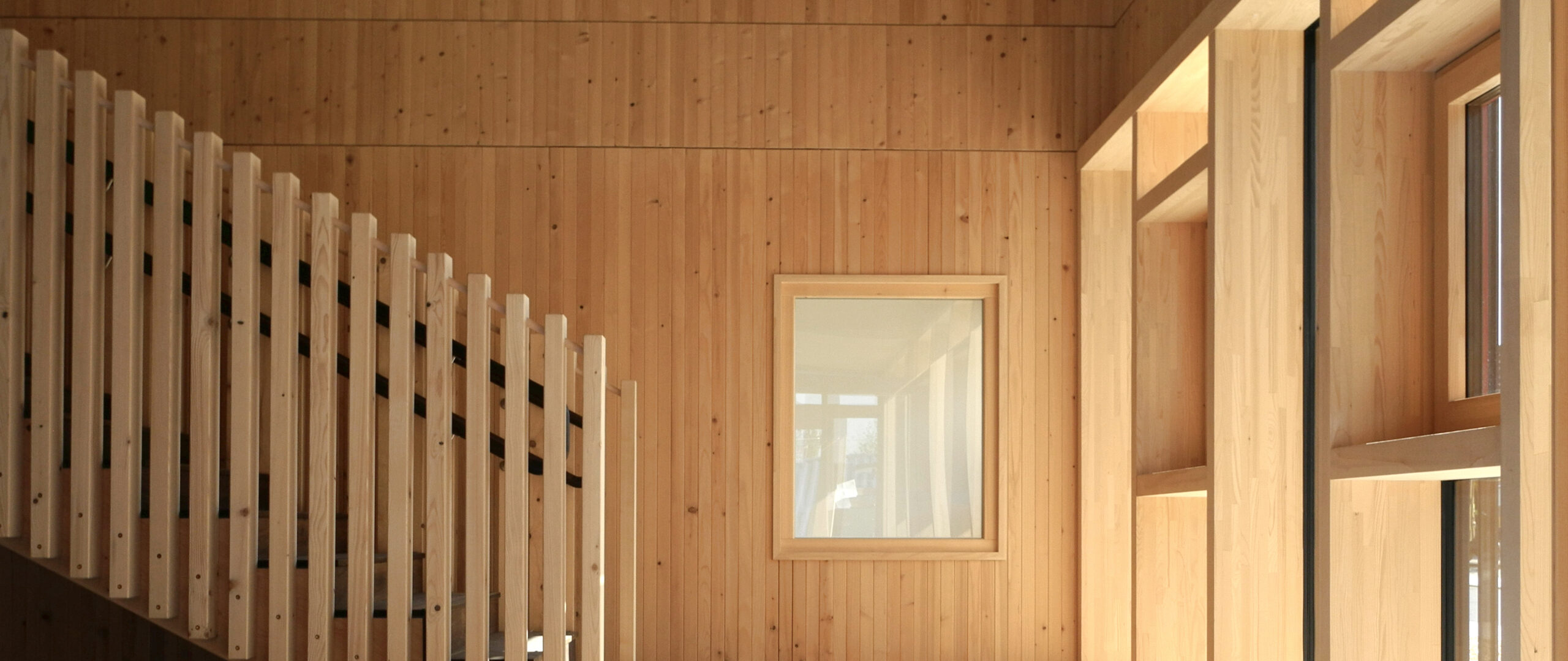 Dübelholzwände im Treppenhaus und Holz-Pfosten-Riegel-Fassade