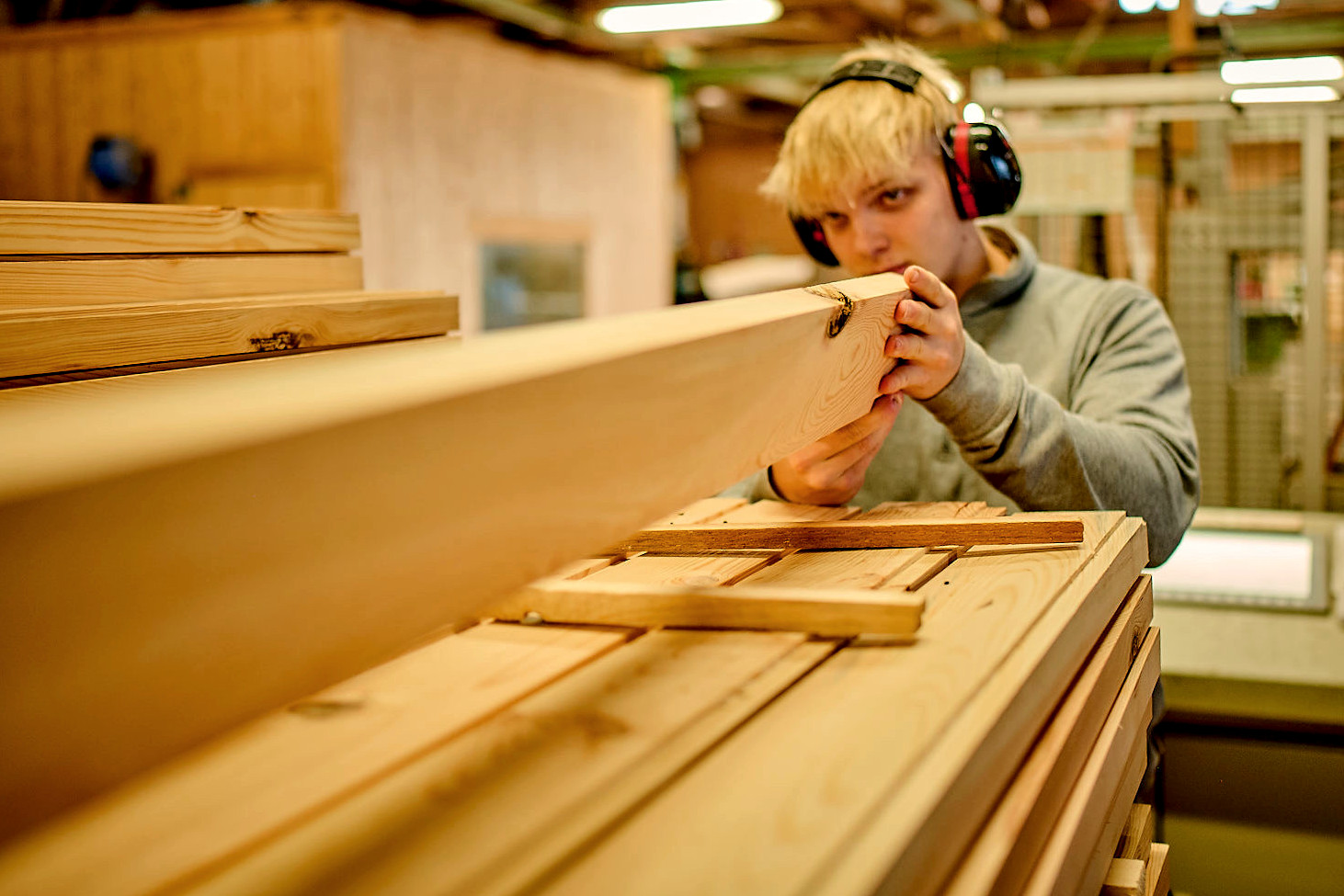 Auszubildender zum Zimmerer prüft Holzlamelle