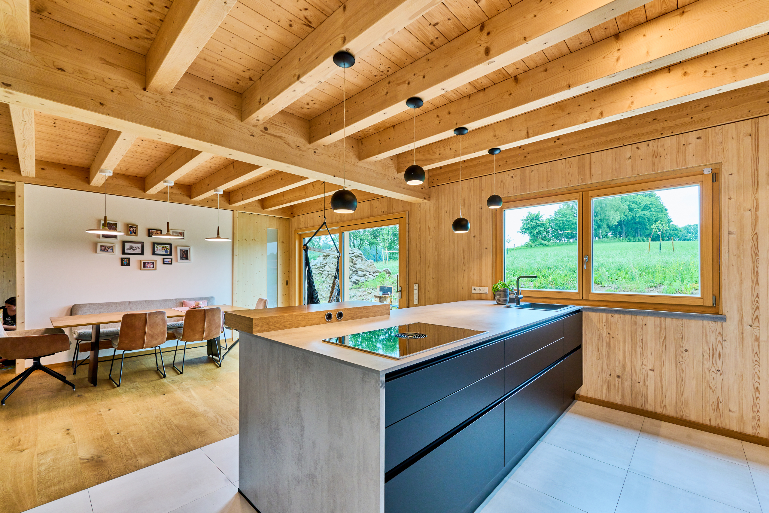 Küchenblock und Essbereich mit Holzbalkendecke und Dübelholzwänden
