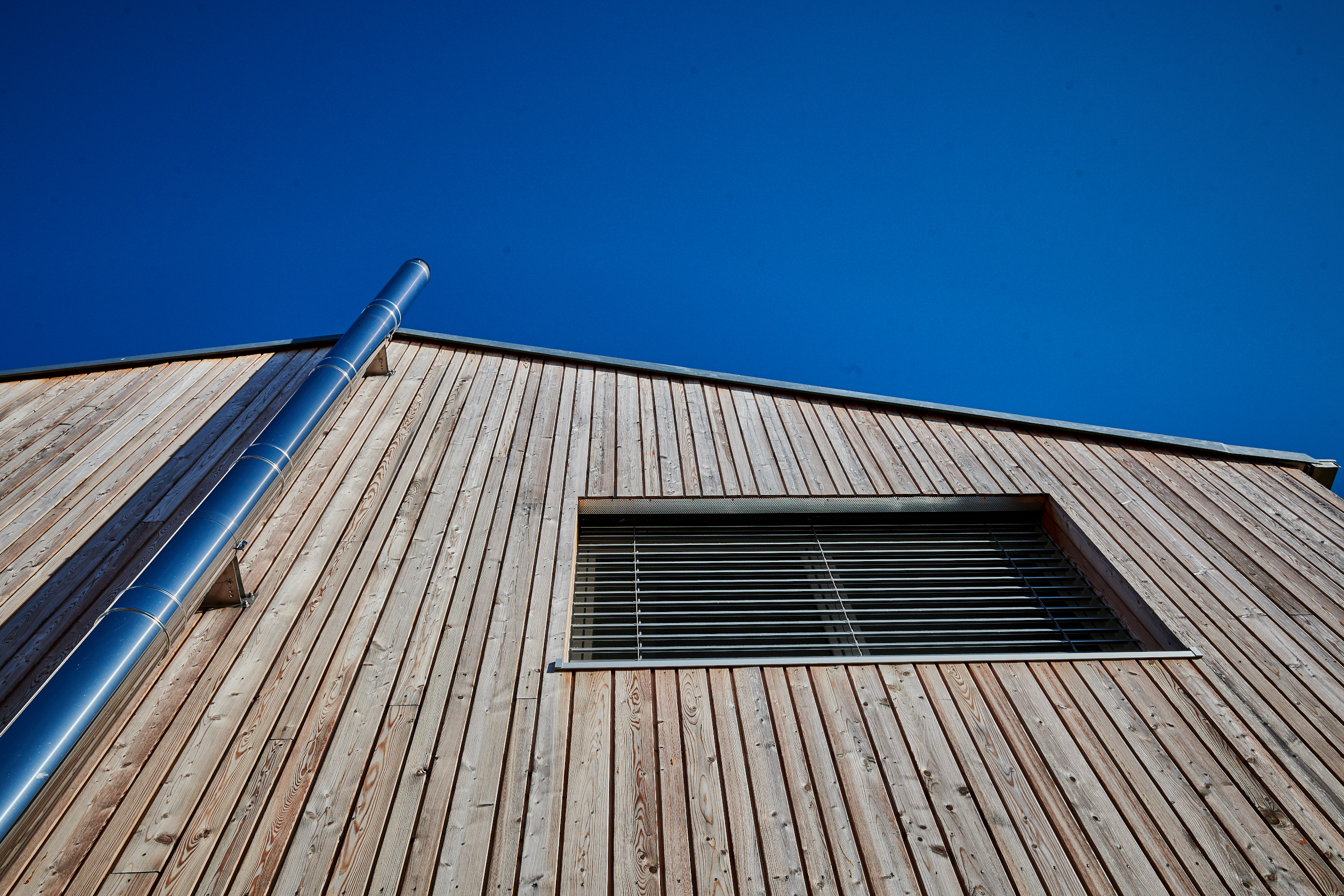 Vertikale Holzfassade an Giebelseite mit Kamin