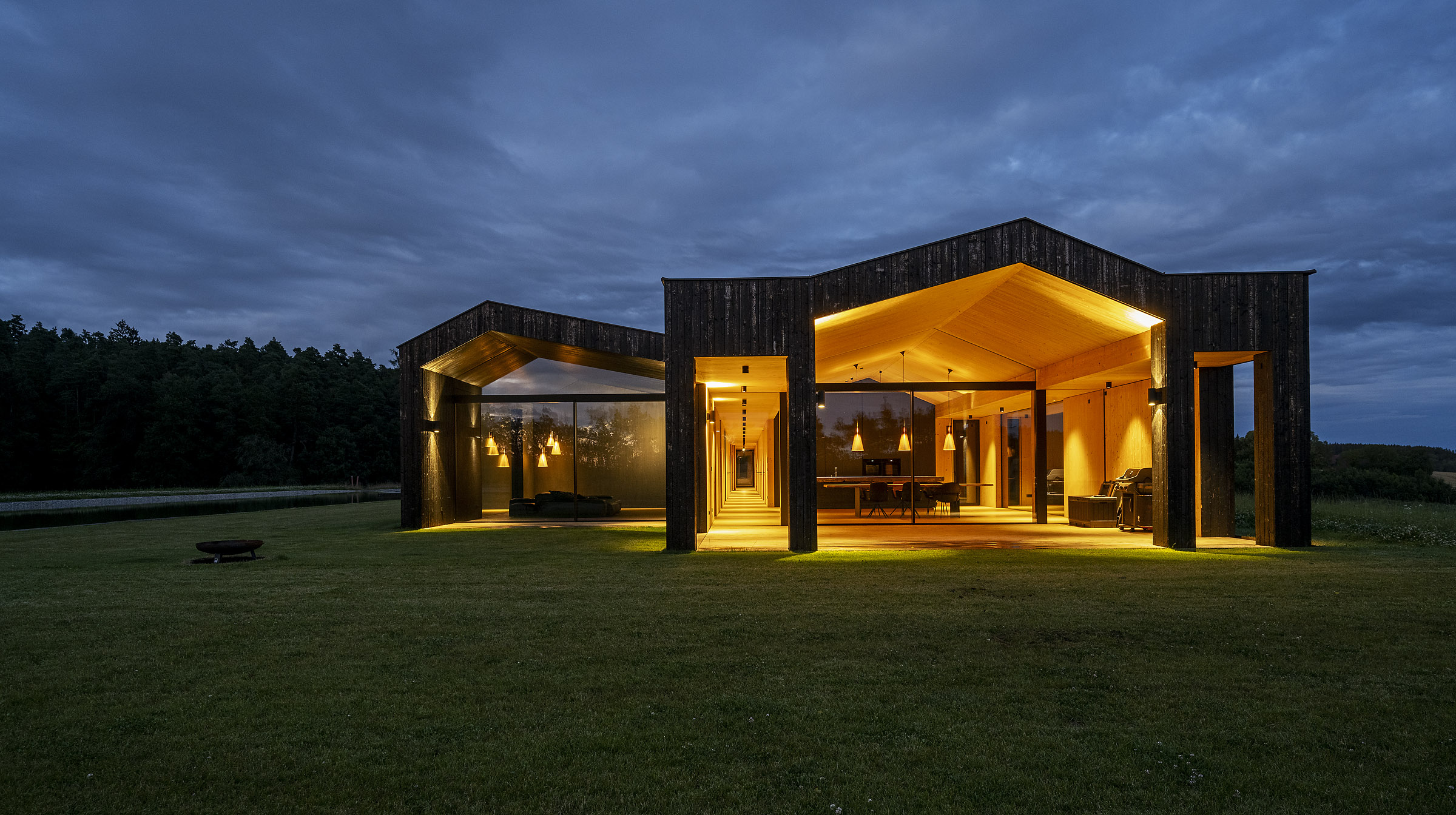 Massivholzhaus mit verkohlter Holzfassade bei Nacht